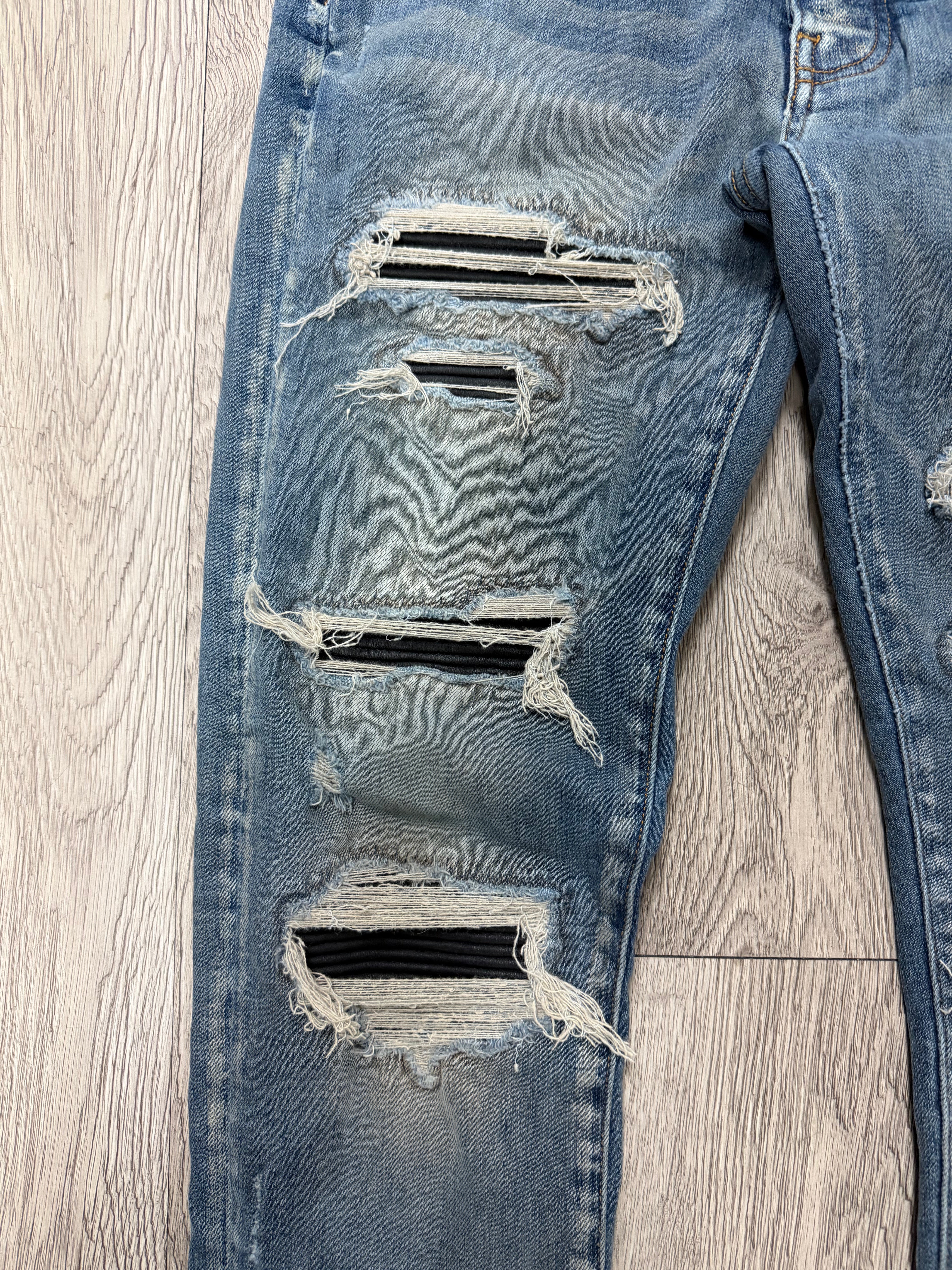 Amiri Light Wash Black Thrasher Patch Jeans