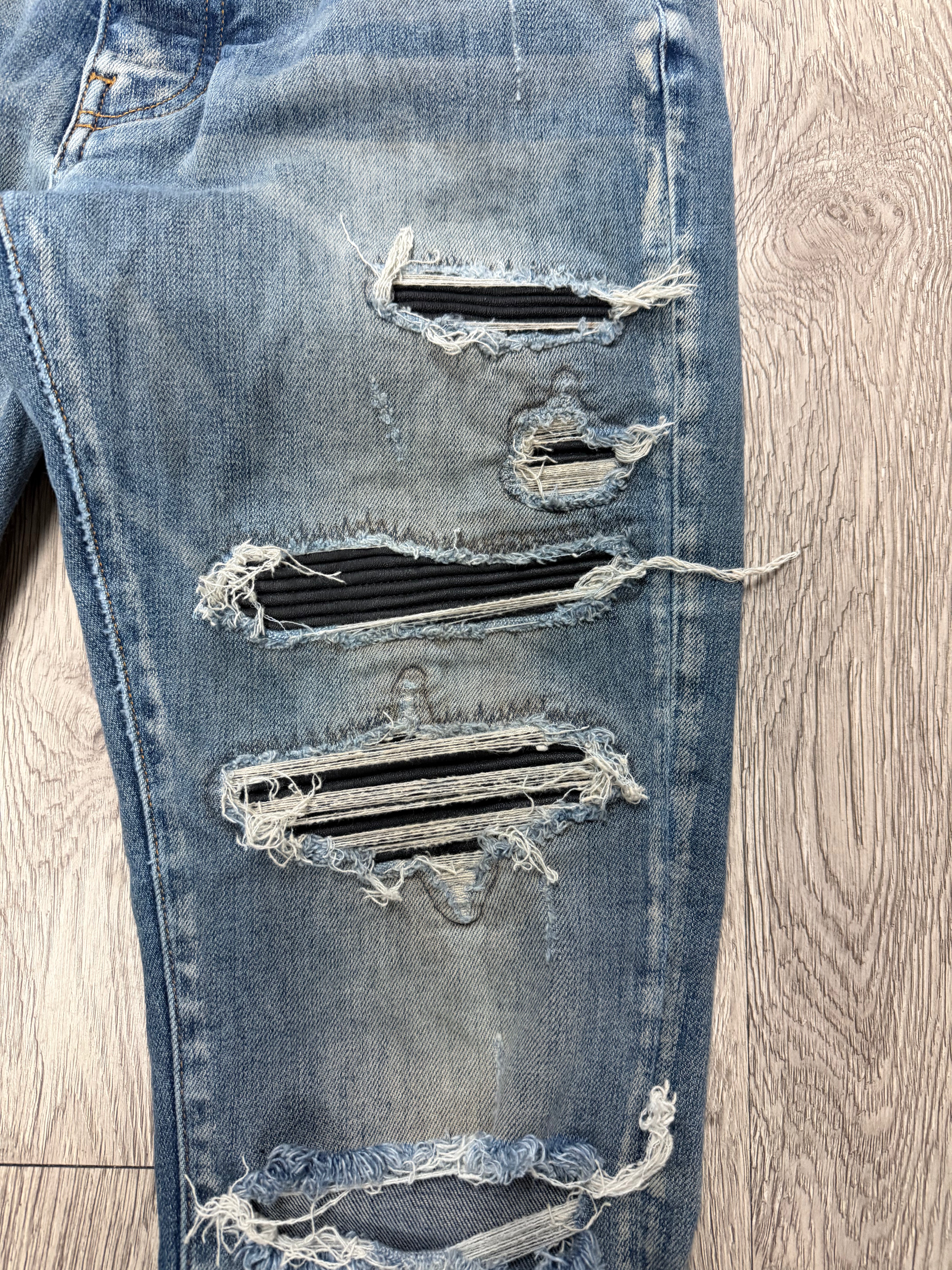 Amiri Light Wash Black Thrasher Patch Jeans